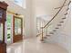 Spacious foyer with a curved staircase, tiled floors, and a decorative front door at 1100 Kensington Ct, Johns Creek, GA 30022