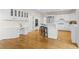 An open concept kitchen with white cabinets, stainless steel appliances, a kitchen island, and hardwood flooring at 1100 Kensington Ct, Johns Creek, GA 30022