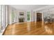 Open-concept living room featuring hardwood floors, a fireplace, and an adjacent dining room with ample natural light at 1100 Kensington Ct, Johns Creek, GA 30022