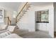 A living room with wood stairs, a bar, and light colored furniture on light carpet at 1100 Kensington Ct, Johns Creek, GA 30022