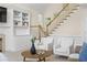 A living room with built in bookcase, fireplace, light colored furniture, and stairs at 1100 Kensington Ct, Johns Creek, GA 30022
