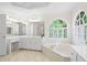 Bright bathroom featuring a soaking tub, lots of cabinet space, and natural light through large windows at 1100 Kensington Ct, Johns Creek, GA 30022