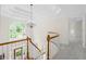 A staircase with white railings and wood banisters leading to a carpeted hallway and entryway at 1100 Kensington Ct, Johns Creek, GA 30022