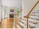 Bright staircase featuring hardwood steps, white risers and railings, and natural light from the front living room at 1100 Kensington Ct, Johns Creek, GA 30022