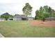 Large backyard with well-maintained lawn and landscaped area with mature shade trees and shrubs behind a gray sided house at 15 Worthington Dr, Villa Rica, GA 30180