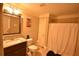 Bathroom featuring granite countertop vanity, toilet, framed mirror, and shower with a white curtain at 15 Worthington Dr, Villa Rica, GA 30180