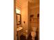 Charming powder room features a pedestal sink, decorative mirror, and stylish shelving at 15 Worthington Dr, Villa Rica, GA 30180