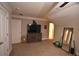 Spacious carpeted bedroom featuring neutral walls, a large television, mirror, and adjacent bathroom at 15 Worthington Dr, Villa Rica, GA 30180