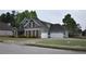Two-story home featuring stone and siding and a three-car garage with extra parking on a wide concrete driveway at 15 Worthington Dr, Villa Rica, GA 30180