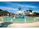 Community pool with a splash bucket and a water slide, with a clubhouse in the background at 15 Worthington Dr, Villa Rica, GA 30180