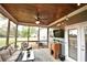 Cozy screened-in porch with wicker furniture, ceiling fan, string lights, and a mounted television at 15 Worthington Dr, Villa Rica, GA 30180