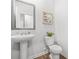 Modern powder room featuring a pedestal sink and a toilet, complemented by wood-look flooring and neutral paint at 3135 Ellenton Dr, Lithia Springs, GA 30122