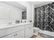 Bright bathroom features double sinks, white cabinets, a large mirror, and marble print shower at 3135 Ellenton Dr, Lithia Springs, GA 30122