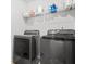 Efficient laundry area with modern, grey front-load washer and dryer and wire shelving for storage at 3135 Ellenton Dr, Lithia Springs, GA 30122