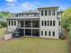 Back exterior featuring an outdoor fireplace, covered porch, and spacious backyard with walkout basement at 340 Colewood Way, Atlanta, GA 30328
