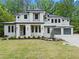 Striking two-story modern home featuring a stone facade, two-car garage, and professionally landscaped front yard at 340 Colewood Way, Atlanta, GA 30328