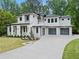 Contemporary two story home featuring stone accents, three-car garage and manicured landscaping at 340 Colewood Way, Atlanta, GA 30328