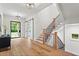 Bright foyer with hardwood floors, modern staircase, a black accent cabinet, and steel-framed glass door at 340 Colewood Way, Atlanta, GA 30328