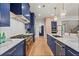Contemporary kitchen with navy blue cabinets, marble countertops, stainless steel appliances, and hardwood flooring at 340 Colewood Way, Atlanta, GA 30328