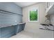 Charming laundry room with blue cabinets, butcher block countertop, and shiplap wall at 340 Colewood Way, Atlanta, GA 30328