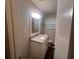 Compact bathroom featuring a modern vanity with granite countertop and a decorative mirror at 3948 Valley Brook Rd, Snellville, GA 30039