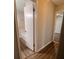 Neutral bathroom with white door, visible bathtub, and contrasting wood-look flooring at 3948 Valley Brook Rd, Snellville, GA 30039