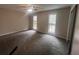 Spacious bedroom featuring plush carpeting and a ceiling fan, illuminated by natural light from two windows at 3948 Valley Brook Rd, Snellville, GA 30039