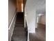 Carpeted staircase with white railing leads to a bright and airy living area with modern flooring at 3948 Valley Brook Rd, Snellville, GA 30039