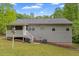 View of the home's backyard featuring a screened in porch with stairs, vinyl siding, and greenery at 401 Farm Brook Ln, Dallas, GA 30157