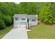 Two-story home with a driveway and a yard surrounded by trees at 401 Farm Brook Ln, Dallas, GA 30157