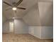 Spacious finished attic featuring neutral walls, carpeted floor, ceiling fan, and doorway leading to additional space at 5621 Wildwood Trl, Lithonia, GA 30038