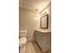 Bathroom featuring a modern vanity, toilet, mirror and light fixture at 5621 Wildwood Trl, Lithonia, GA 30038