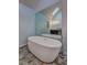 Modern bathroom featuring a stand-alone tub, a large mirror, and stylish tile floors at 5621 Wildwood Trl, Lithonia, GA 30038