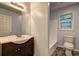 Well-lit bathroom featuring a dark vanity, a mirror, and a toilet with a shower/tub combo at 5621 Wildwood Trl, Lithonia, GA 30038