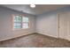 Cozy bedroom with plush carpeting, a window offering natural light, and neutral wall paint at 5621 Wildwood Trl, Lithonia, GA 30038