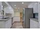 Bright kitchen with white cabinetry, granite countertops, and stainless steel refrigerator at 5621 Wildwood Trl, Lithonia, GA 30038