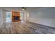 Spacious living room featuring a stone fireplace, ceiling fan, wood-look flooring, and double doors to the sunroom at 5621 Wildwood Trl, Lithonia, GA 30038