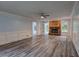 Living room features a stone fireplace, neutral walls, ceiling fan, and wood-look flooring at 5621 Wildwood Trl, Lithonia, GA 30038