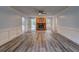 This open living room features a stone fireplace, wainscoting and wood-look floors at 5621 Wildwood Trl, Lithonia, GA 30038