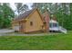Home featuring attached garage, outdoor deck, and lush green yard at 5621 Wildwood Trl, Lithonia, GA 30038