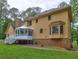 Picture of the back of home featuring outdoor deck, bay window, and lush yard at 5621 Wildwood Trl, Lithonia, GA 30038