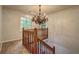 Upper landing with wood railing, carpet, and chandelier at 5621 Wildwood Trl, Lithonia, GA 30038