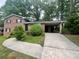 Two-story brick home featuring a covered carport and mature landscaping at 1263 Shoreham Dr, Atlanta, GA 30349