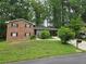 Traditional brick home with a well-manicured front lawn and mature trees and shrubs at 1263 Shoreham Dr, Atlanta, GA 30349