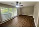 Bright living room featuring wood flooring, a ceiling fan, and a large window at 1263 Shoreham Dr, Atlanta, GA 30349