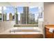 Bathroom featuring a soaking tub and beautiful skyline views during the day at 20 10Th Nw St # 2003, Atlanta, GA 30309