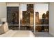 Bedroom view showcasing a breathtaking cityscape at sunset, seen through floor-to-ceiling windows at 20 10Th Nw St # 2003, Atlanta, GA 30309