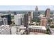 A detailed city view showcasing many modern skyscrapers, green trees, and clear skies at 20 10Th Nw St # 2003, Atlanta, GA 30309