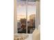 Bedroom features an amazing city view at sunset framed by modern curtains at 20 10Th Nw St # 2003, Atlanta, GA 30309