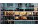Exterior shot of a building with walls of windows, showing multiple apartments inside at 20 10Th Nw St # 2003, Atlanta, GA 30309